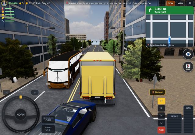 A Hudson Trucks semi driving through the city at noon
